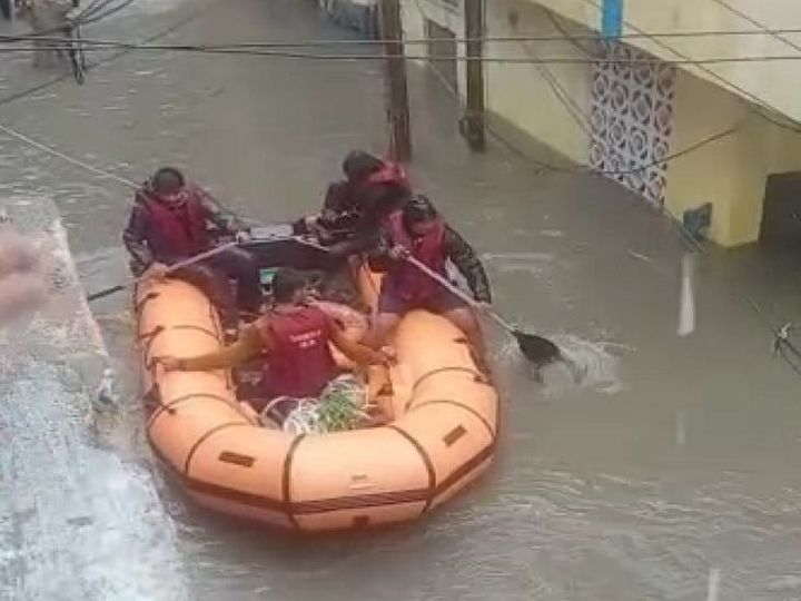 पानी में फंसे परिवारों का नाव और ट्